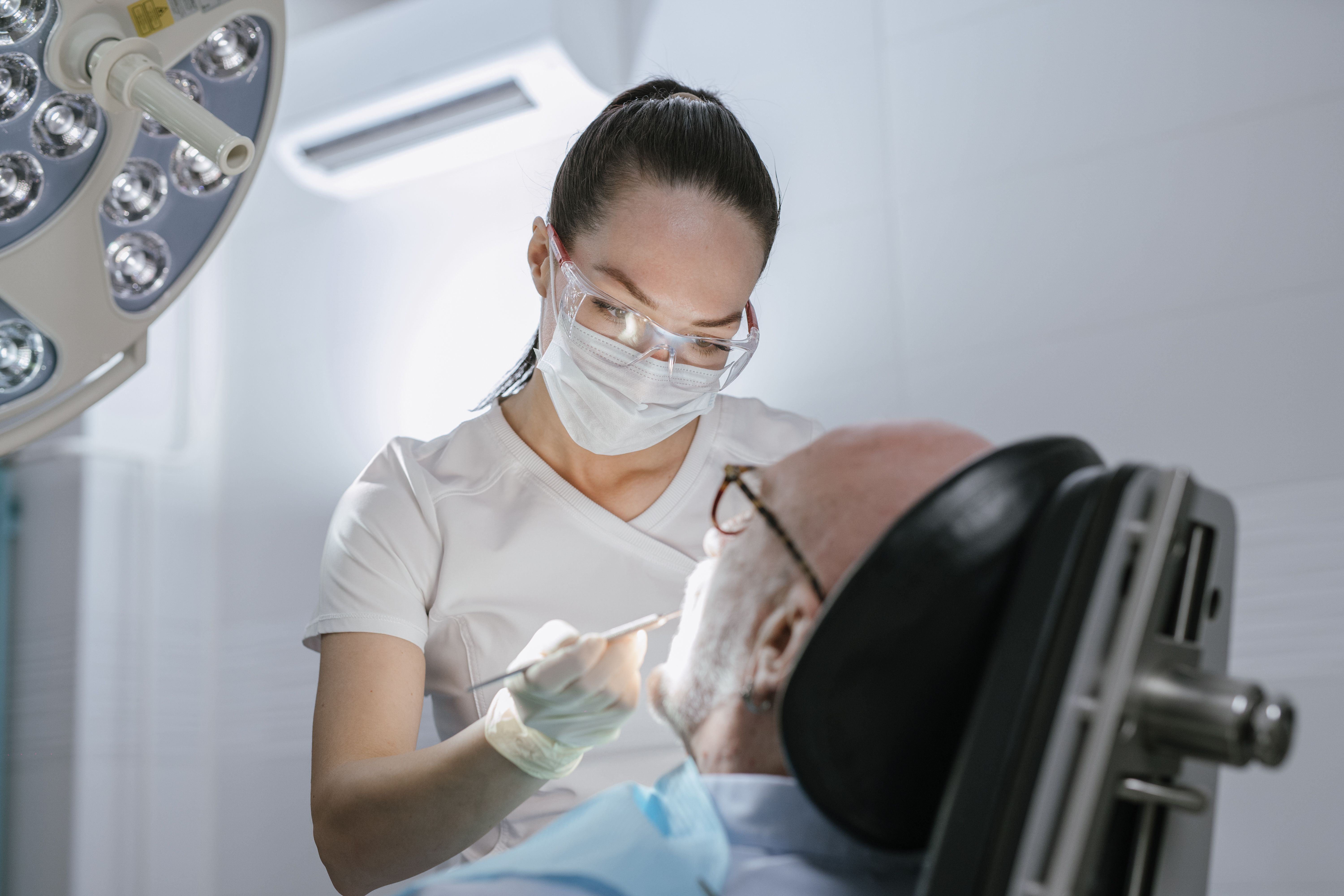 A hygienist showing a tooth-shade guide to an older patient.